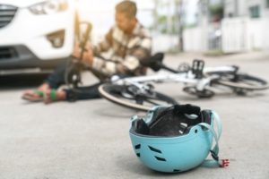 A cyclist and their bicycle lying on the road after a road traffic accident