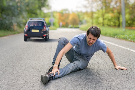 a pedestrian lying on the floor after being hit by a car