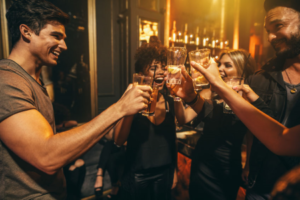 A group of people socialising with drinks inside a bar