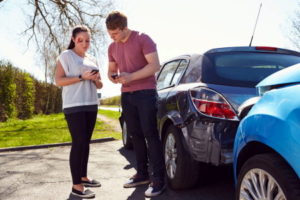 Two drivers involved in an accident exchange drunk driver's details. 