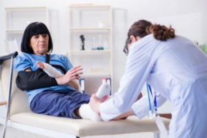 Woman with injured limbs receiving treatment from a nurse in a hospital