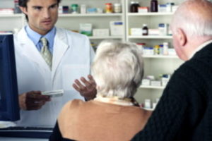 a man offering advice on a presciption to an elderly couple