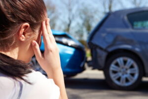 An injured driver looking at two cars involved in a rear shunt accident