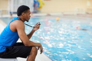 a lifeguard looking out over a busy swimming pool