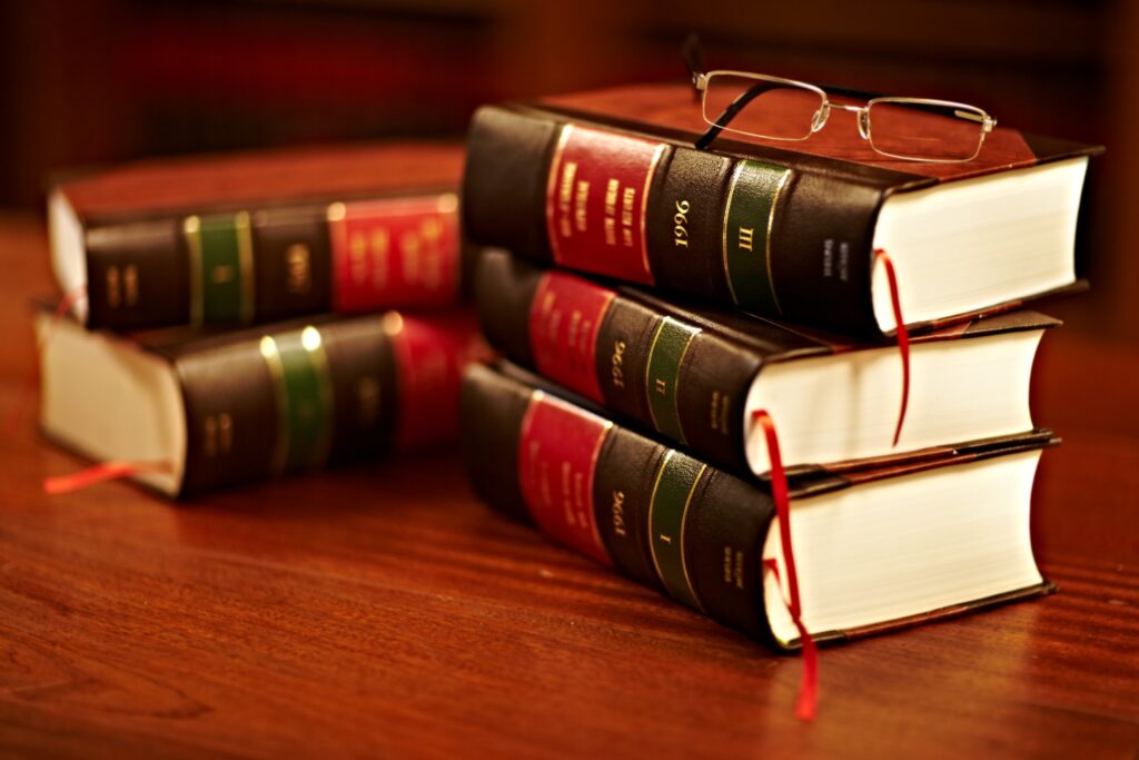 a pile of law books with a pair of glasses on the top