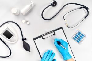 gynaecologist negligence represented by gloves hands writing on a clipboard surrounded by medical devices. 