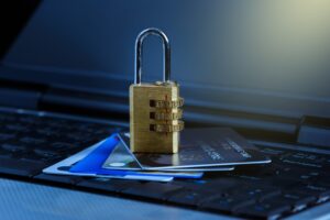 a padlock sitting on top of a number of bank cards which rest upon a laptop keyboard