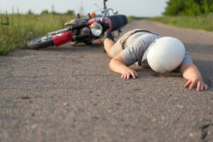 a person lying on the ground after having a motorbike accident