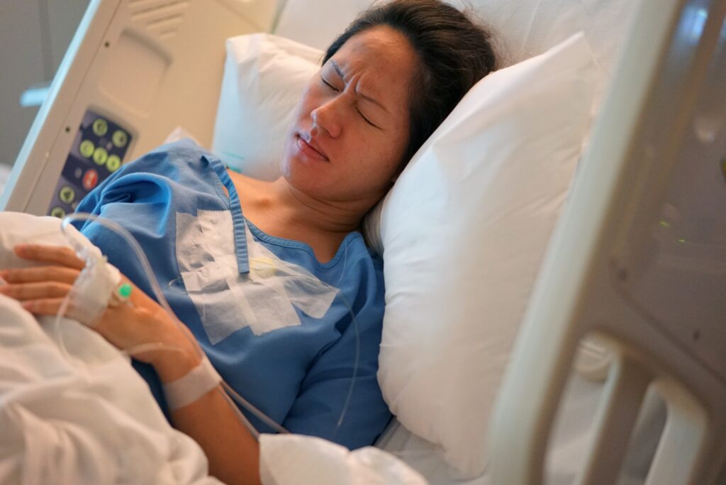 a woman lying in a hospital bed recovering from sepsis caused by bed sores