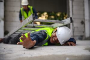 A worker lying on the ground after being crushed by a ladder.