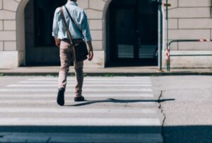 A pedestrian walks across a zebra crossing. 