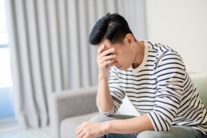 Man with psychological injury sat down and holding his head with his hand