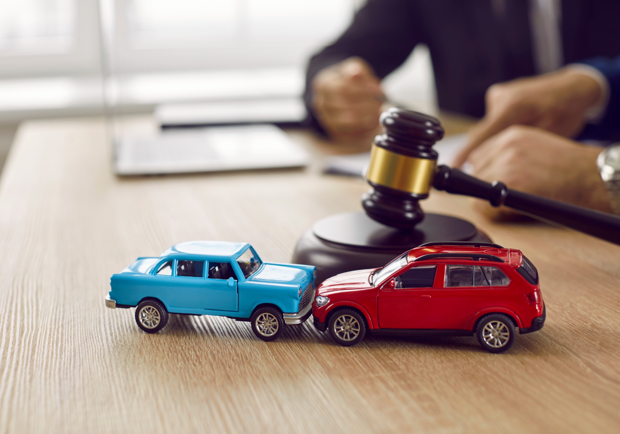 Two toy cars crashed on a lawyer's desk. 