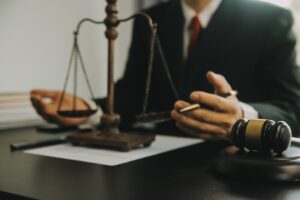 A No Win No Fee psychological injury claim solicitor sat at a desk and holding a pen in their left hand