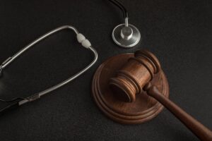 A wooden gavel next to a stethoscope.