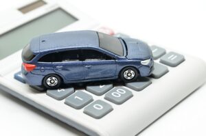 Personal injury compensation illustrated with a toy car on a calculator. 