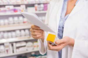 A pharmacist checks medication before dispensing. 