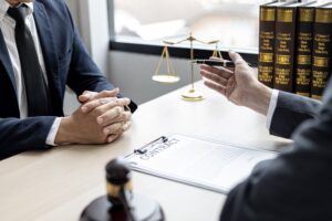 A solicitor discussing a potential cycling pothole claim with his client at a desk.