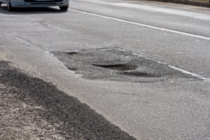 A deep pothole or road defect shown as a potential hazard for all motorists