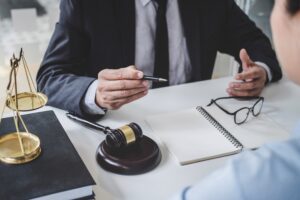 A No Win No Fee solicitor sat with his client at a desk discussing how to claim for a care worker data breach