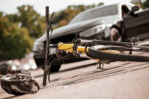 a bicycle on a road having been hit by a car in a cycling accident