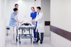 Hospital staff pulling a bed through a hallway