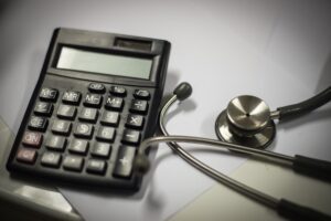 A calculator next to a stethoscope to represent medical negligence compensation.