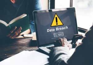 An IT worker receiving notification of a personal data breach while at a desk with a colleague
