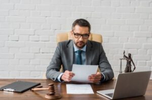 A personal injury solicitor sitting at a desk reviews a form for a public liability insurance claim
