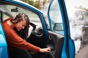 A woman injured in a car crash holds her neck in pain. 