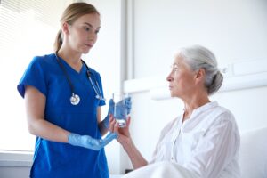 A medical professional hands medication to a patient. 