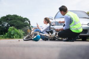 E-SCOOTER RIDER SAT ON GROUND AFTER A COLLISION WITH MOTOR VEHICLE