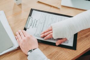 SELF-EMPLOYED PERSON COMPLETING WORKERS COMPENSATION CLAIM PAPERWORK AT A DESK