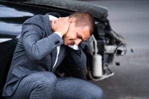 a man holding his neck in pain following a car accident