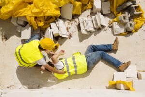 An man in a high-vis jacket on the floor. He has been injured at work. 
