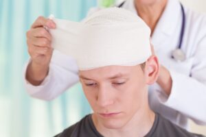 YOUNG MAN HAVING HEAD BANDAGED AFTER HAVING HAD SOME KIND OF HEAD OR BRAIN INJURY