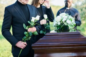 People in grief standing around the coffin of a loved one