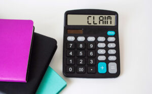 A calculator with the word 'claim' on the screen