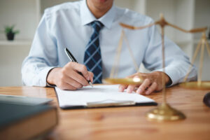 Personal injury lawyer sigining paperwork for arm injury claim.