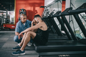 IMAGE OF PERSON SITTING ON TREADMILL AFTER SUFFERING A GYM ACCIDENT