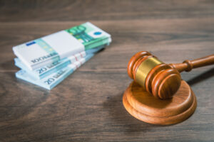 A stack of notes and a gavel on a table to represent criminal injuries compensation.