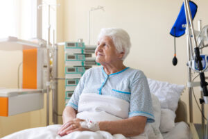 A vulnerable patient sits in a hospital bed.