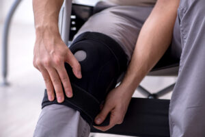A person sat in a wheelchair with a knee brace.