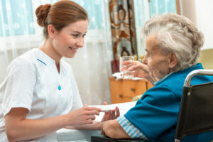 A nurse and an elderly resident in a nursing home.