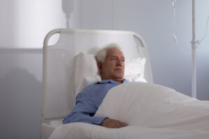 A hospital patient lays in bed. 