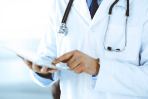 A doctor uses a tablet computer to access medical records.