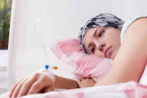 A female cancer patient is in a hospital bed.