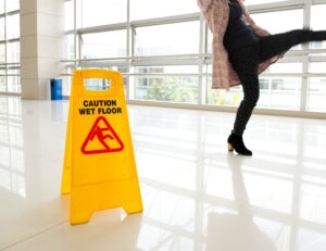 A worker suffers tendon damage after slipping on a wet office floor.