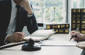A No Win No Fee lawyer sits behind a desk and talks to a client