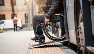 A man in a wheelchair exits a bus while going to a meeting with a personal injury solicitor.